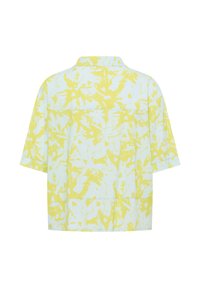 Korte mouwen shirt van lichtblauwe stof met een gele bloemenpatroon. Het heeft een kraag en een ontspannen ontwerp met een rechte zoom.