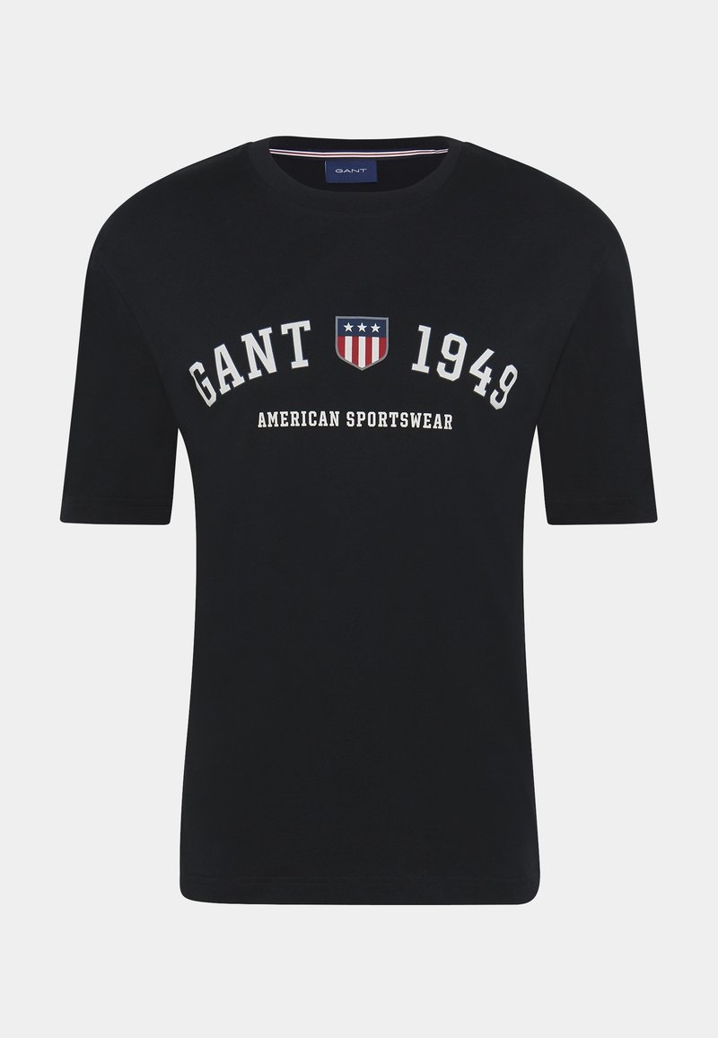 Marineblå bomulds t-shirt med rund halsudskæring, korte ærmer og hvid tekst med et skjoldemblem, der viser røde, hvide og blå accenter.