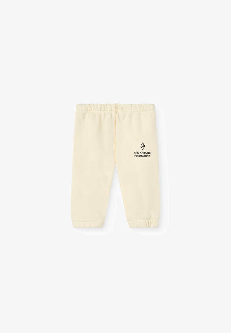 Helle gelbe Sweatpants aus Baumwolle, mit einem elastischen Bund und gerafften Bündchen, und einem kleinen schwarzen Logo an der Seite.