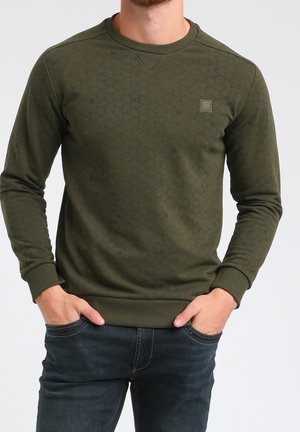 Sweatshirt vert olive avec un motif géométrique texturé, col et poignets côtelés, et un petit logo sur la poitrine. À associer avec un jean foncé.