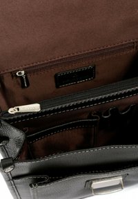Interno di una borsa in pelle nera con fodera in tessuto marrone, dotata di molteplici tasche e un compartimento con zip. Sono visibili dettagli in metallo argentato.