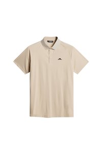 Beige polo tröja med korta raglanärmar, klassisk krage och en liten svart logotyp på vänster bröst. Tillverkad av ett smidigt, lätt material.