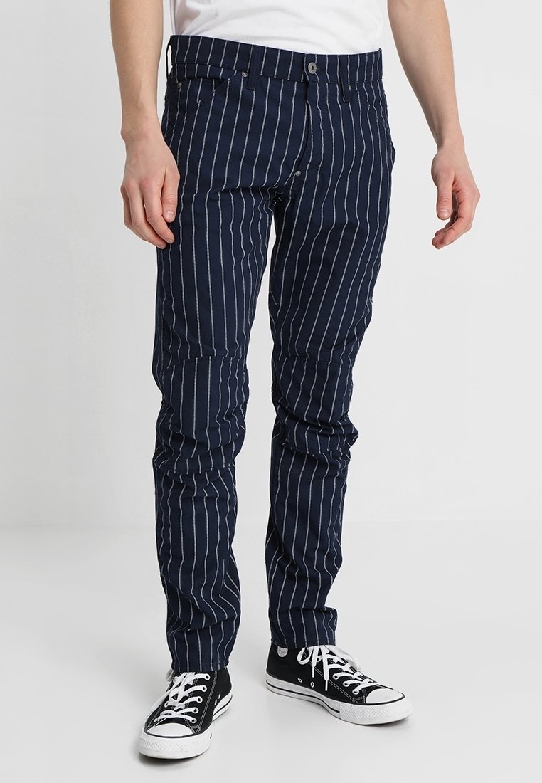 Marinblårandiga byxor i en bomullsblandning, med smal passform, bälteshällor, fram- och bakfickor samt knappstängning.