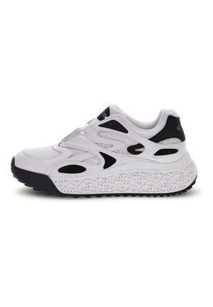 Sneaker atletica bianca e nera con tomaia in rete, accenti neri decorativi e suola patterned con forme interconnesse in rilievo.
