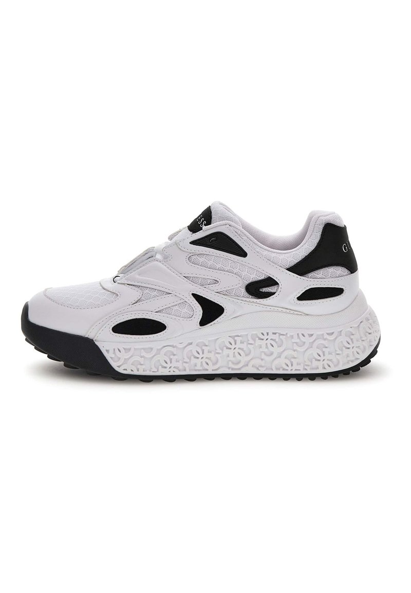 Sneaker atletica bianca e nera con tomaia in rete, accenti neri decorativi e suola patterned con forme interconnesse in rilievo.
