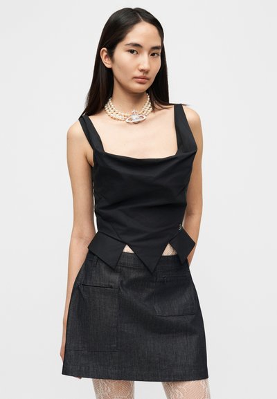 Μαύρο ρυθμισμένο τοπ με φαρδιές τιράντες και τετράγωνο ντεκολτέ, σε συνδυασμό με μια σκούρα μίνι φούστα από τζιν με πλαϊνές τσέπες.