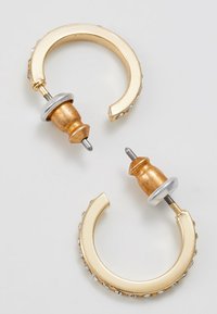 Orecchini a cerchio placcati oro con una finitura testurizzata, dotati di un accento metallico e piccoli gemme trasparenti lungo il bordo. Design con perno regolabile.