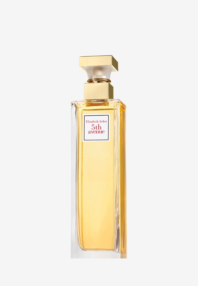 Flacon de parfum en verre carré avec un corps transparent et un capuchon doré. L'étiquette présente un texte rouge sur un fond blanc. Le liquide est d'un jaune pâle.
