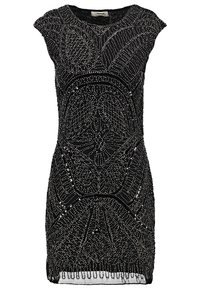 Svart klänning prydd med intrikata mönster av silverpärlor och paljetter, med korta ärmar och en figurnära silhuett. Texturerade detaljer längs fållen.