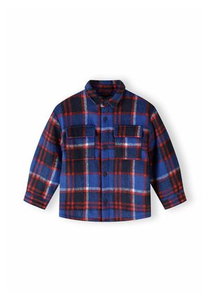 Chemise en flanelle à carreaux bleus, noirs et rouges. Dotée d'une fermeture à boutons sur le devant, d'un col et de deux poches poitrine avec rabats. Texture douce.