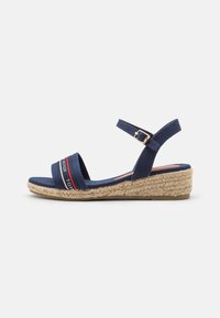 Marineblauwe espadrille sandalen met twee stoffen banden en een gesp. Heeft een geweven jute plateau en een gestructureerde zool.