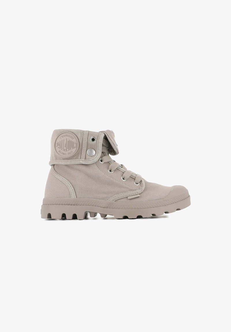 Bottines en toile beige clair avec un bout arrondi, semelle en caoutchouc, œillets en métal et languette repliable avec un logo.