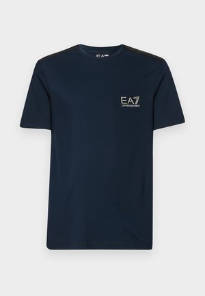 Navyblauwe katoenen t-shirt met korte mouwen, ronde halslijn en een gouden opdruklogo op de borst; heeft gestructureerde zwarte schouderaccenten.