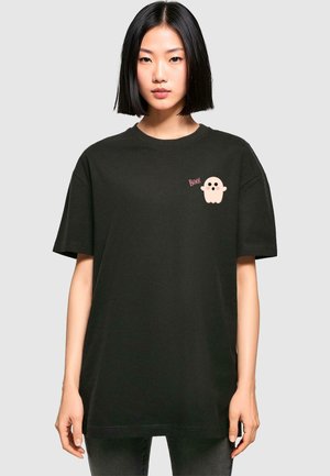 T-shirt in cotone nero con maniche corte, caratterizzato da una grafica di un fantasma rosa e il testo "Boo!" sulla parte sinistra del petto. Design semplice, vestibilità rilassata.