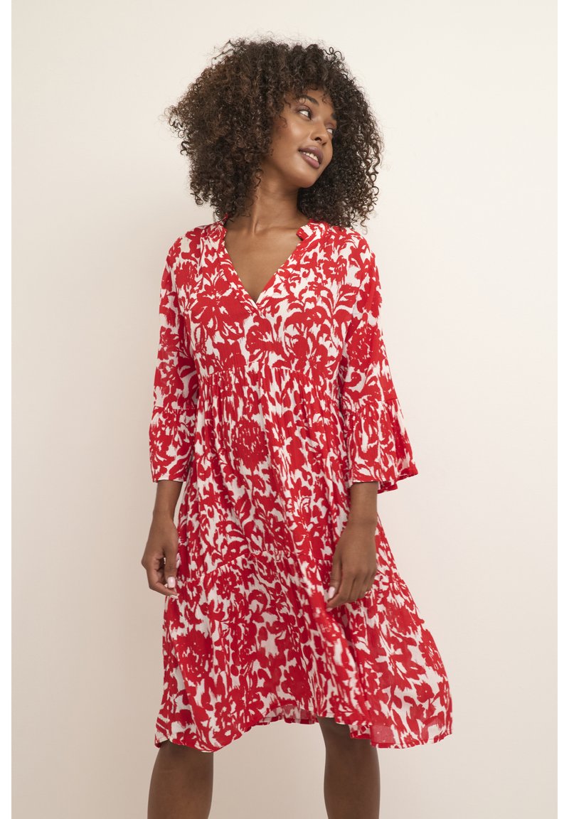 Rotes und weißes Blumendruckkleid mit V-Ausschnitt, Dreiviertelärmeln und geraffter Taille, aus leichtem Stoff.