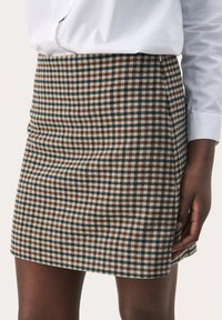 Rutet mini-nederdel i brune, blå og beige nuancer. Stoffet har en blød tekstur med en tætsiddende pasform og høj talje.