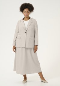 Lichtgrijze blazer met streepdessin en bijpassende midirok. Beide stukken hebben een relaxte pasvorm, een enkele knoopsluiting en een gladde textuur.