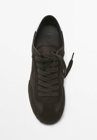 Sneaker marrone con una tomaia in suede e tessuto, punta rotonda, lacci piatti, colletto imbottito e una accentuata suola in gomma bianca alla punta.