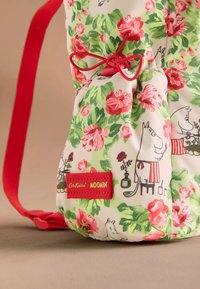 Stof met bloemmotief in groen en wit met rode accenten; met Moomin-personages; voorzien van een rood merklabel en een decoratieve strik.