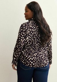 Koszula z długim rękawem w ciemnym granacie z białym abstrakcyjnym wzorem. Gładka tkanina, dopasowany krój z mankietami na guziki, zaokrąglony dół i detal w postaci yoke z tyłu.