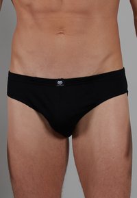Caleçons en coton noir avec une ceinture douce et un petit logo, offrant un ajustement confortable et une texture lisse. Design minimaliste, sans motifs.