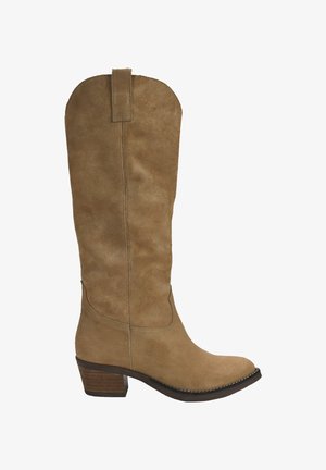 Bota de ante color tan hasta la rodilla con puntera redondeada, tacón de madera apilada y detalles de costura a lo largo de la costura. Tiene una pestaña para facilitar su puesta.