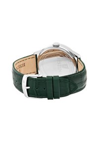 Correa de reloj de cuero verde con acabado texturizado, caja de acero inoxidable y herrajes plateados. Presenta un fondo de caja transparente y hebilla de pasador.