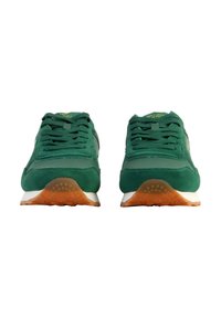 Zapatillas deportivas de ante verde con lengüetas acolchadas, cordones redondos y suelas de goma blanca que cuentan con una suela exterior naranja para mayor tracción.