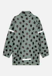 Vandafvisende jakke i dæmpet grøn med sorte, uregelmæssige pletter. Har en krave, elastiske manchetter og reflekterende hvide striber.