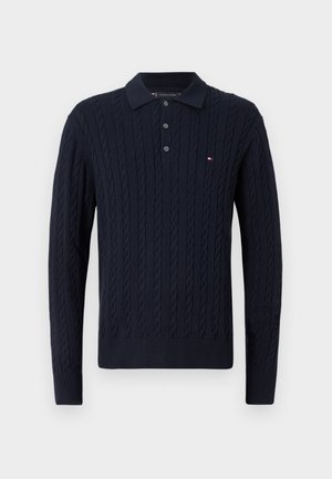 Granatowy sweter w warkoczowy splot z kołnierzykiem, trzema guzikami i ściągaczami na mankietach oraz u dołu. Posiada mały akcent z logo.