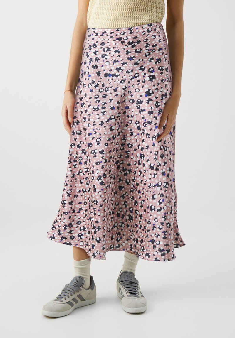 Rosa midi-skjørt med svart og hvit blomstermønster, glatt tekstur, utsvulmet design, brukt sammen med grå joggesko og beige sokker.
