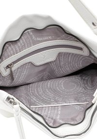 Interno di una borsa in pelle bianca testurizzata, con una tasca con zip e foderato in tessuto stampato con motivi testuali circolari.