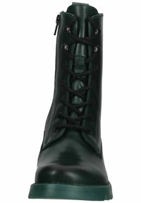 Botas de tobillo de cuero verde con cordones en la parte delantera, puntera redonda y suela texturizada. Cuenta con una cremallera lateral para facilitar el uso.