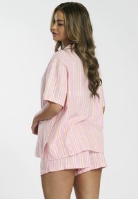 Short-sleeve pink striped shirt with white, yellow, and orange lines, paired with matching shorts. The fabric appears lightweight and soft.