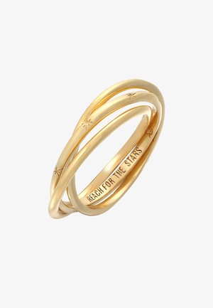 Guld triple band ring med et snoet design, der har små stjerneskripter og sætningen "REACH FOR THE STARS" på den indre band.