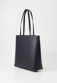 Svart lær totebag med jevn tekstur, flat design og to lange håndtak, med en strukturert form og minimal detaljering.