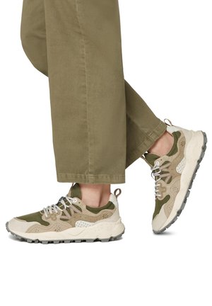 Grønne og beige sneakers med et struktureret design, der har snørebånd, en polstret sål og en løkke ved hælen.