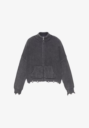 Siva rebrasta jopa z zadrgo, visokim ovratnikom, dvema sprednjima žepoma in neobdelanimi robovi. Izdelana je iz teksturirane, pletene tkanine.