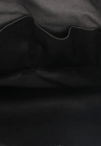 Interno della borsa nera con fodera in tessuto morbido, caratterizzato da bordi lisci e senza hardware o motivi visibili. Testurizzato per una presa e una durata ottimali.