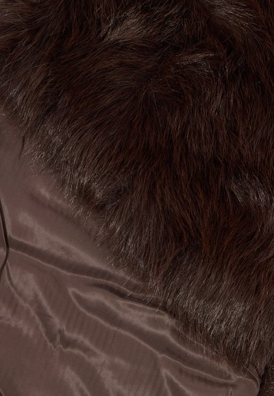 Forro de pelúcia castanha por cima de um tecido de satin castanho escuro e suave. A textura é felpuda, com fios visíveis, proporcionando uma aparência acolhedora.
