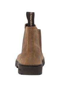 Las botas de tobillo de gamuza marrón presentan una lengüeta marcada "El Naturalista", con un acabado texturizado y una suela de goma negra en contraste.