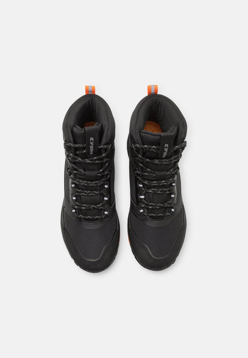 Botas de senderismo negras con un upper texturizado, un bucle en el talón de acento naranja y cordones negros. Presenta detalles reflectantes y un interior acolchado.