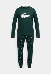 Zeleno dolgo majico z dolgimi rokavi in belo grafiko krokodila, združeno z zelenimi hlačami z majhnimi belimi vzorci krokodila. Mehki bombažni material.