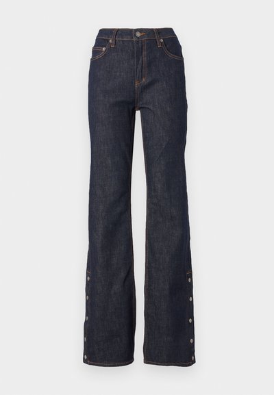 Mørke blå jeans med høy midje, utsvingte ben, kontrasterende oransje sømmer og sidelommer langs falden for justerbar passform.