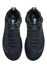 GORE-TEX vandringsskor med en marinblå mesh-ovandel och svarta gummidetaljer, reflexsnören och en texturerad sula för bra grepp.