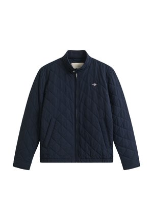 Marineblauwe doorgestikte jas met een opstaande kraag, ritssluiting aan de voorkant en zijzakken. Voorzien van een klein logo op de borst en een gladde textuur.