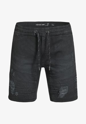 Crni traper šorts s pojasom na vezanje, sa rebrastim detaljima i pohabanim mrljama na prednjem delu. Dužina do sredine butina.