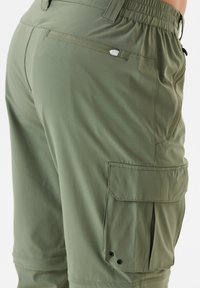 Olivgrön cargo-byxor med en slät yta, med elastisk midja, sidofickor och en bakficka med tryckknapp.