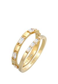 Guldfarvede ringe med rektangulære klare sten, poleret finish, en med accentuerede sten og den anden med en glat ring.