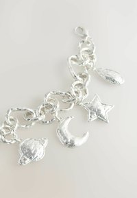 Sølv charms armbånd med en tekstureret kæde og charms i form af en planet, en halvmåne, en stjerne og en dråbe. Glat, poleret finish.